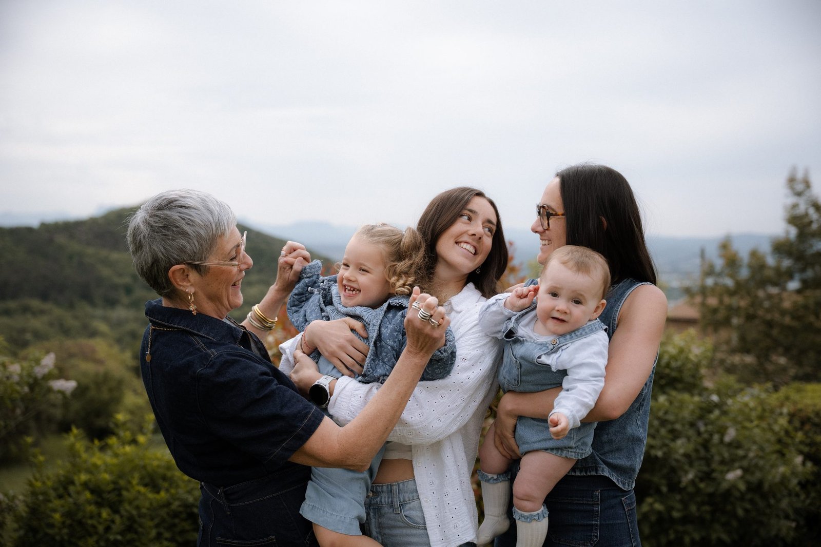 Trois générations de femmes réunies avec deux jeunes enfants, en extérieur