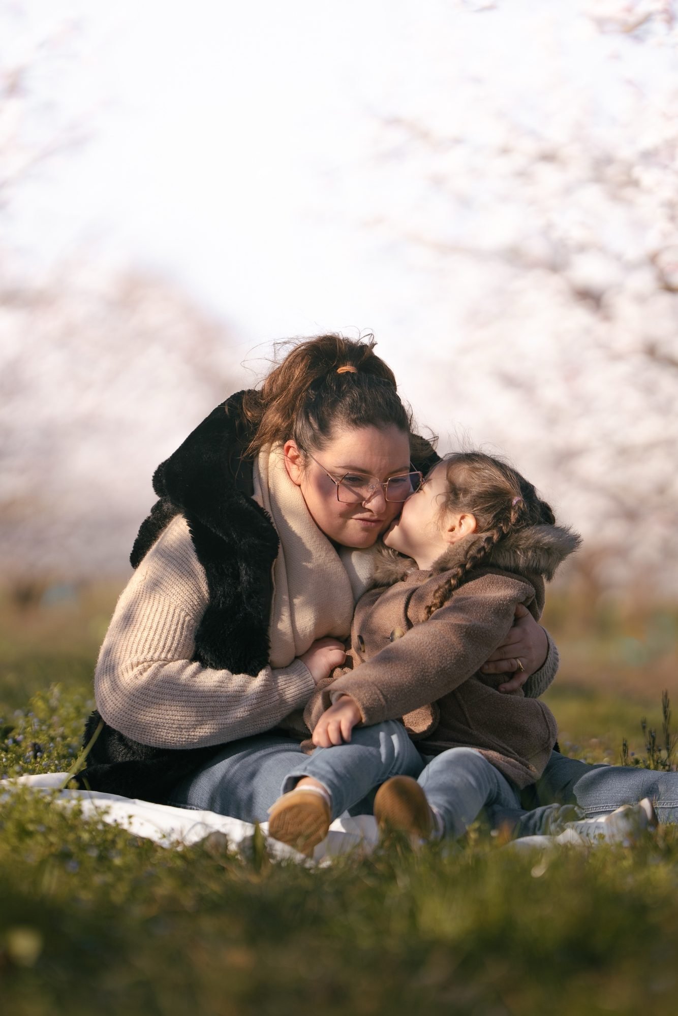 Un bébé souriant regarde dehors, porté par sa maman