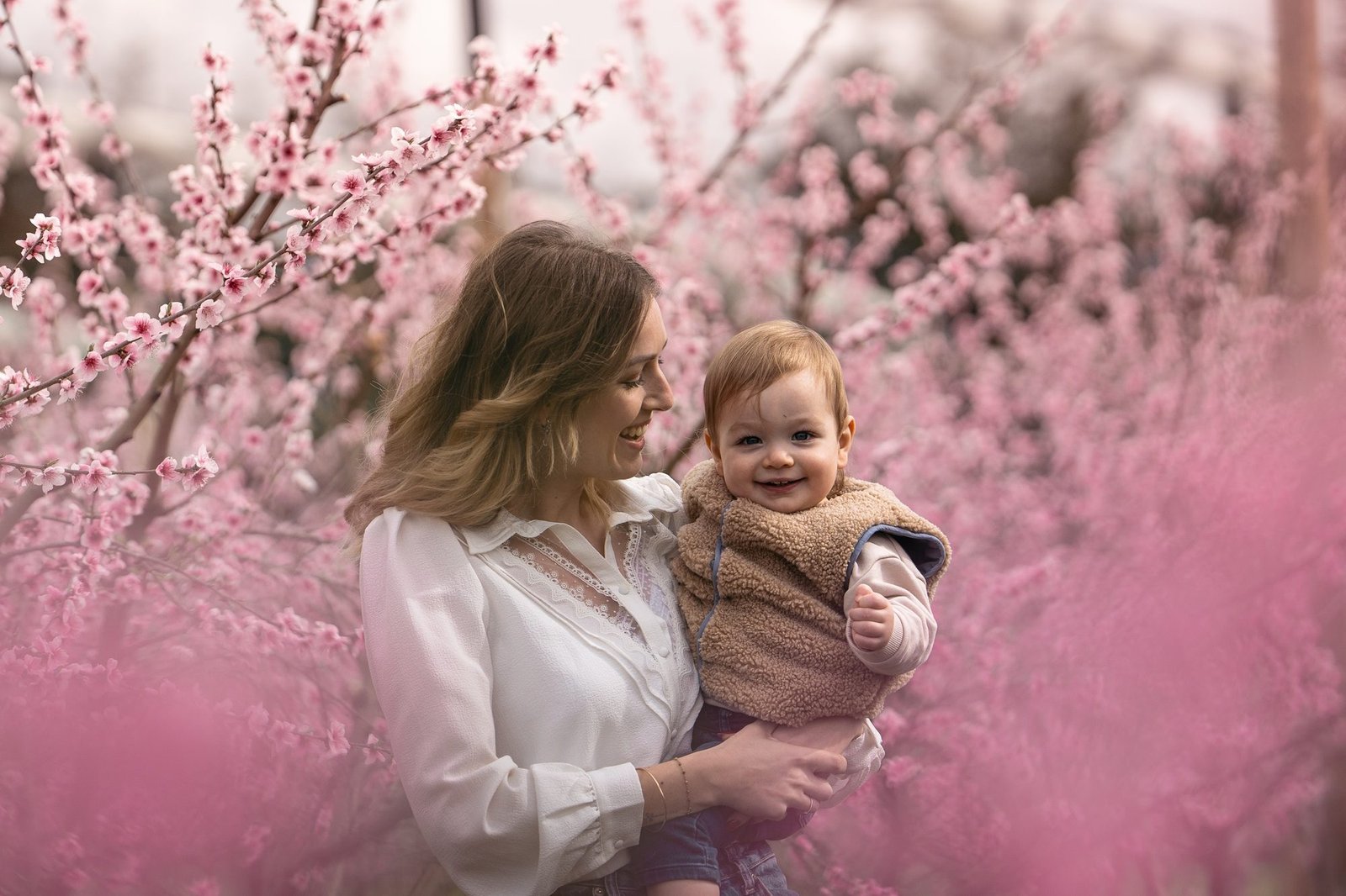 Bébé curieux observe le jardin depuis les bras de sa mère