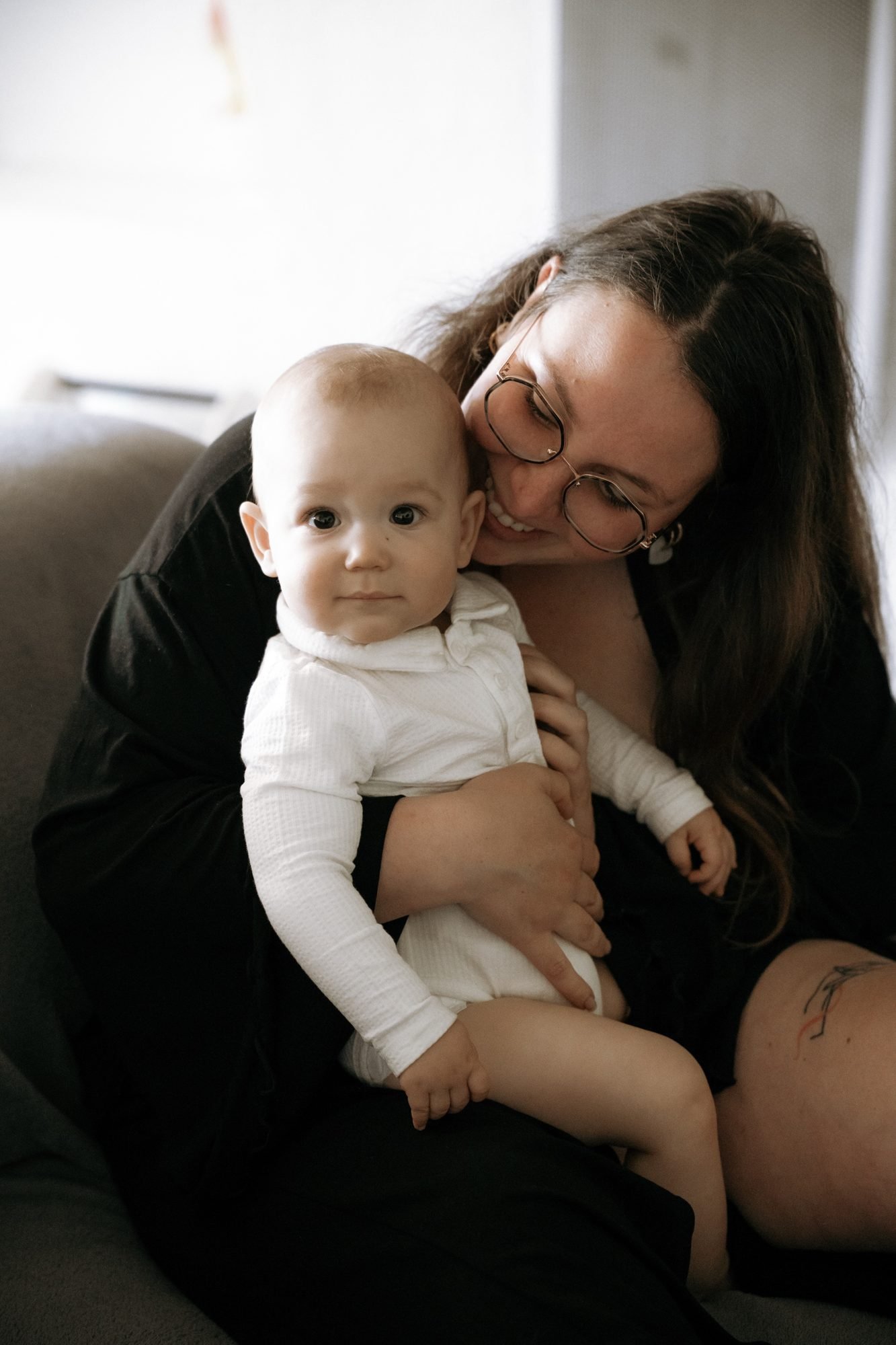 Bébé blotti dans les bras de sa maman, entourée de verdure