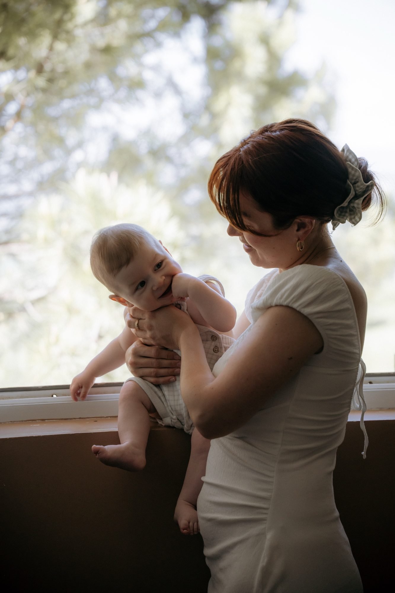 Bébé curieux observe le jardin depuis les bras de sa mère