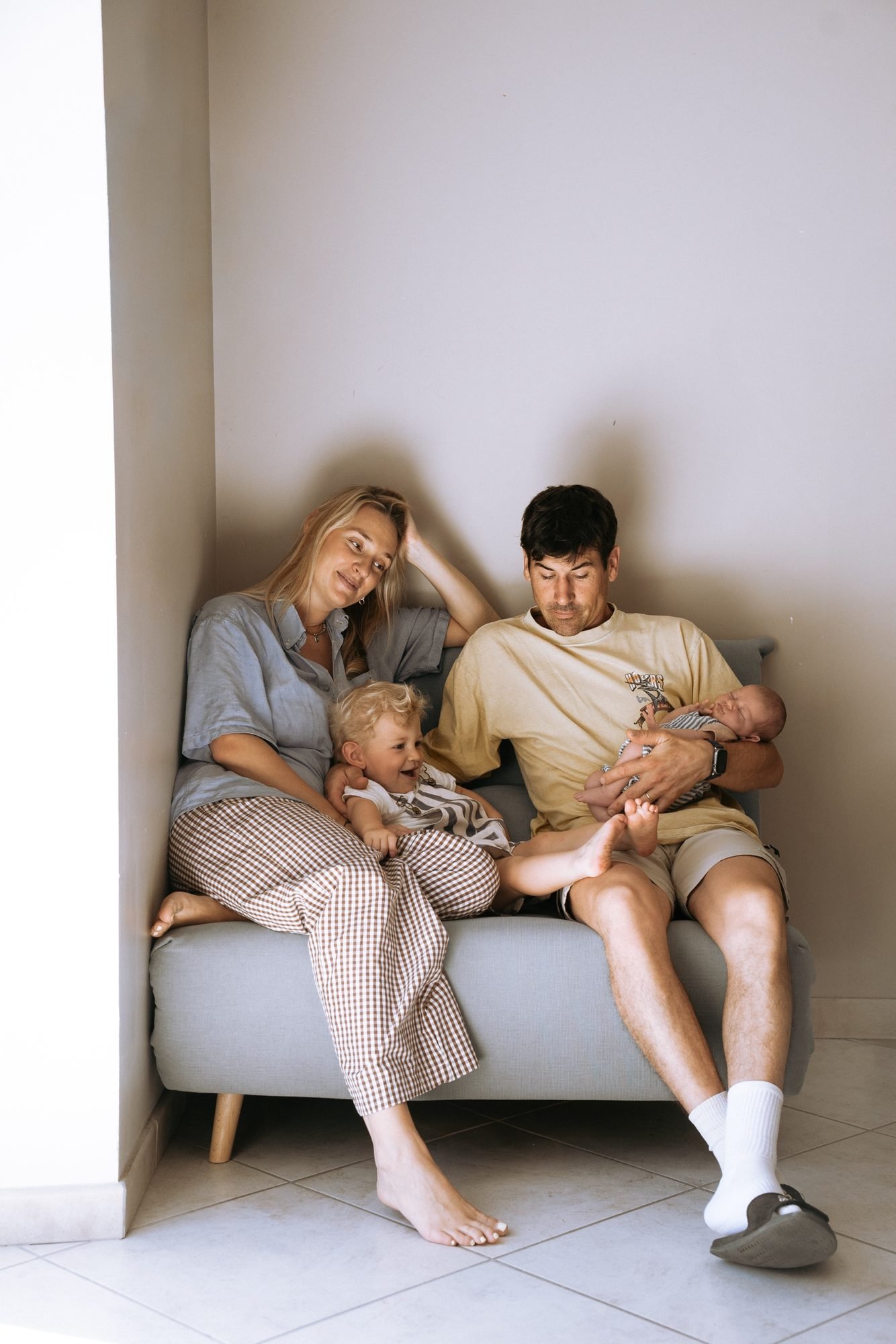 Bébé joue avec les mains de sa maman, décor de pierre