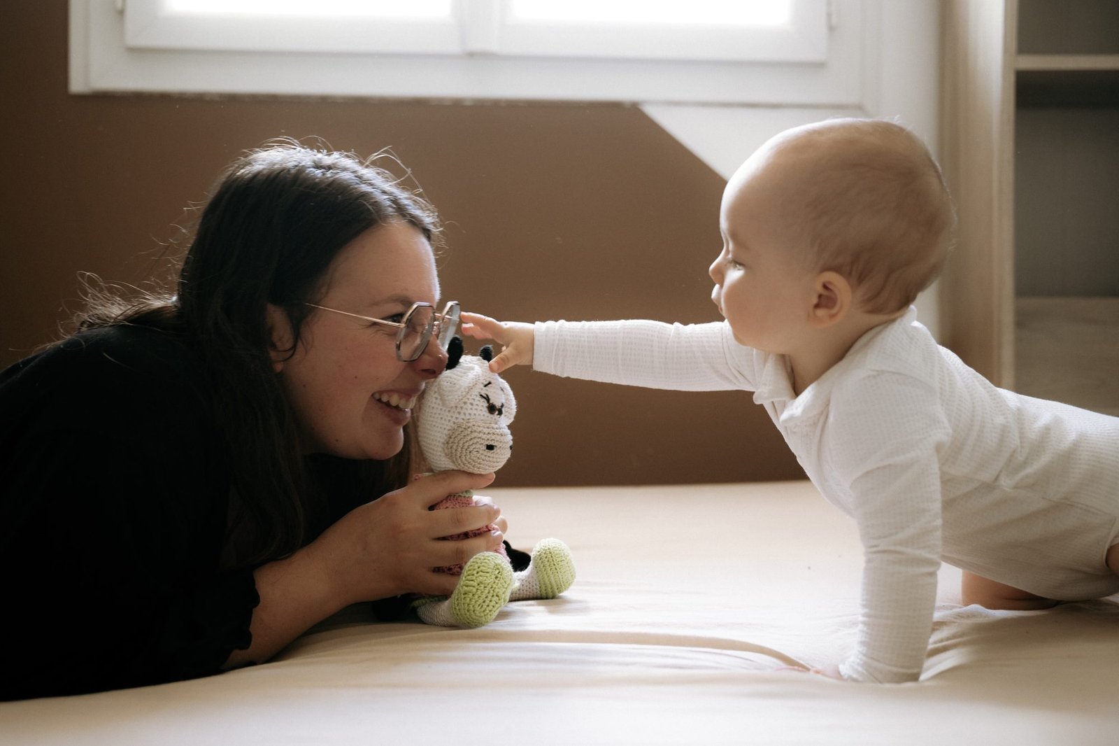 Bébé endormi contre l'épaule de sa maman, lumière du matin
