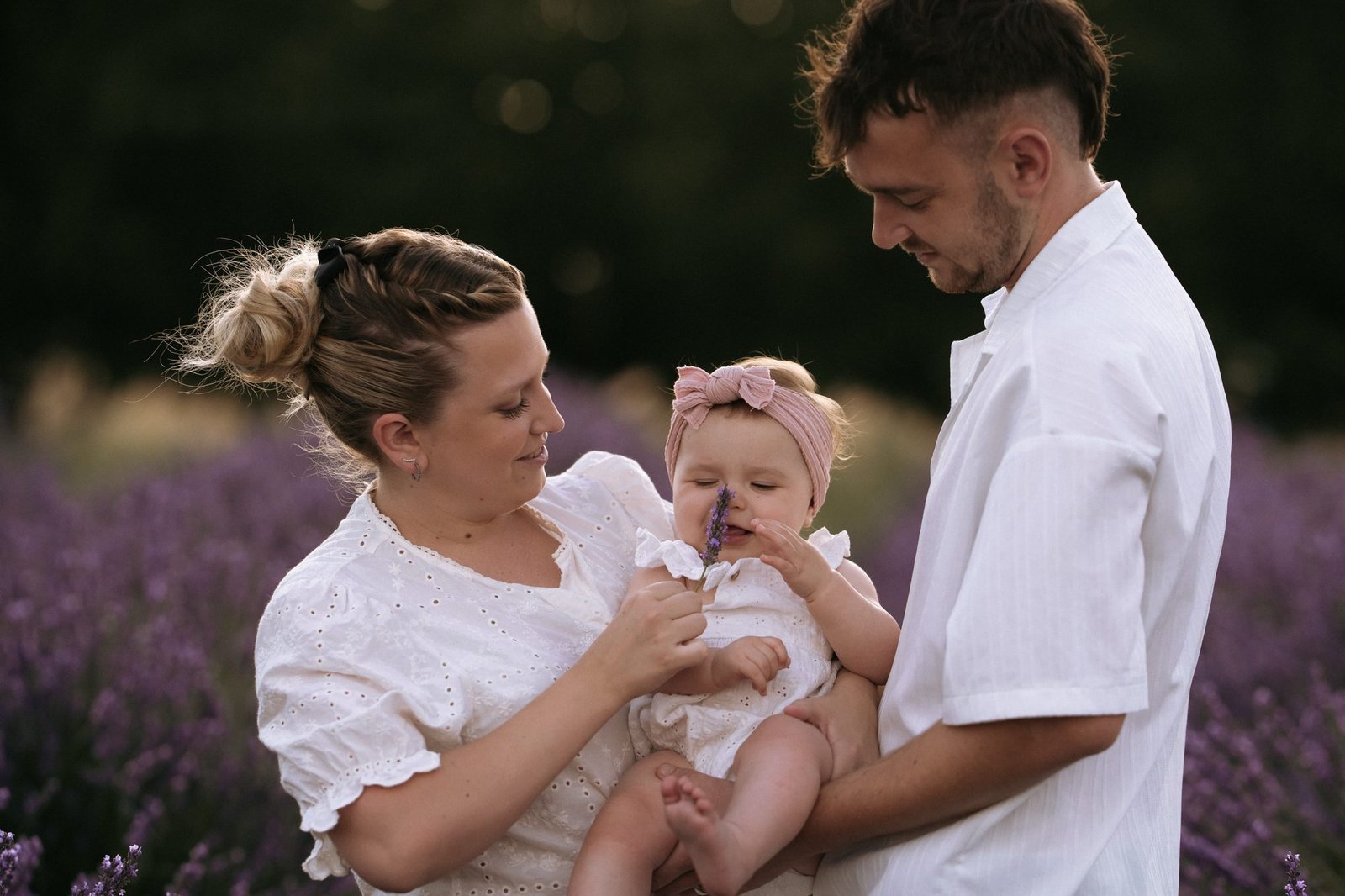Papa soulève son bébé avec joie dans les champs de lavande