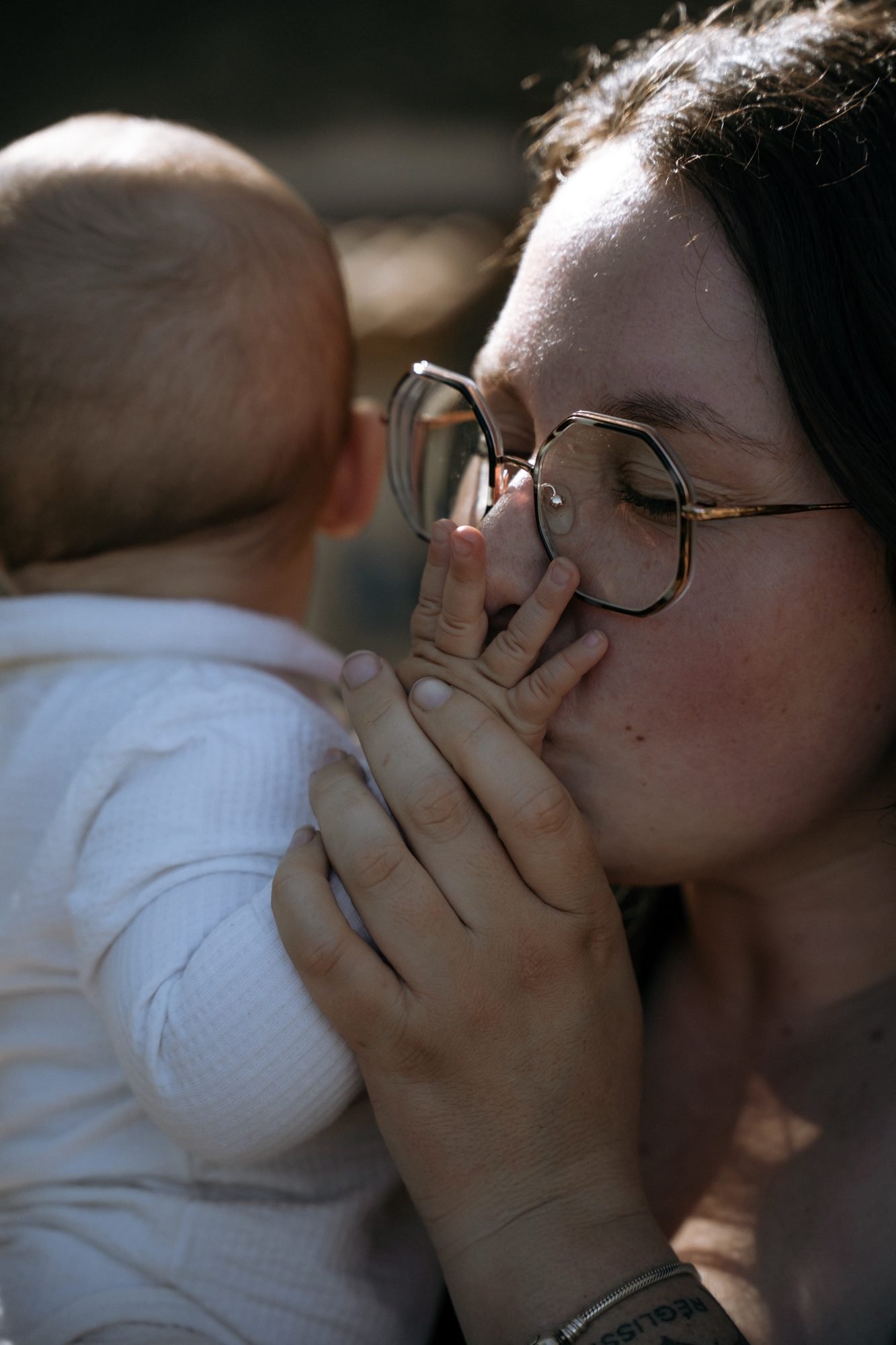 Bébé apaisé dans les bras de sa maman, lumière naturelle