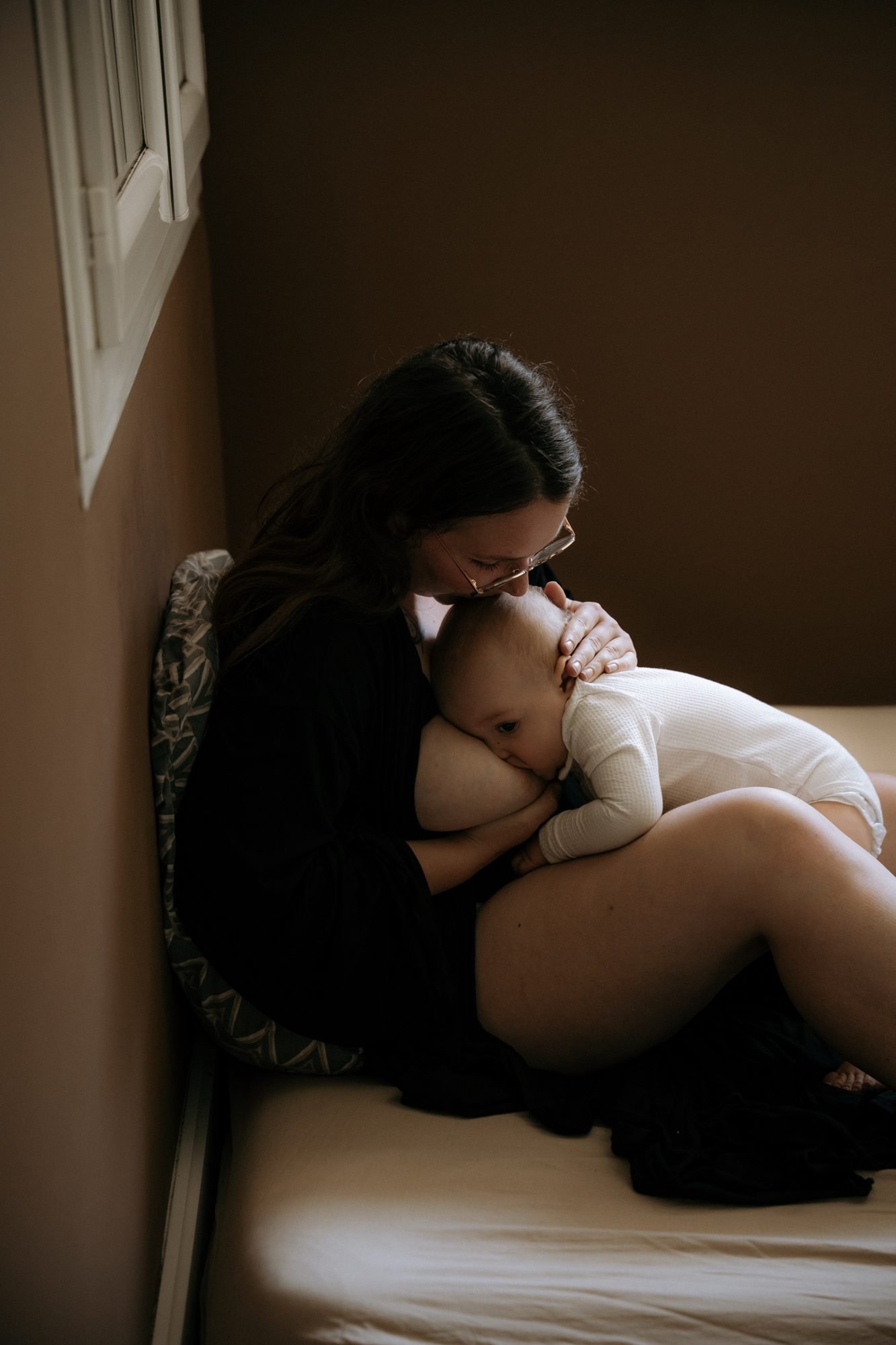 Bébé blotti dans les bras de sa maman, entourée de verdure