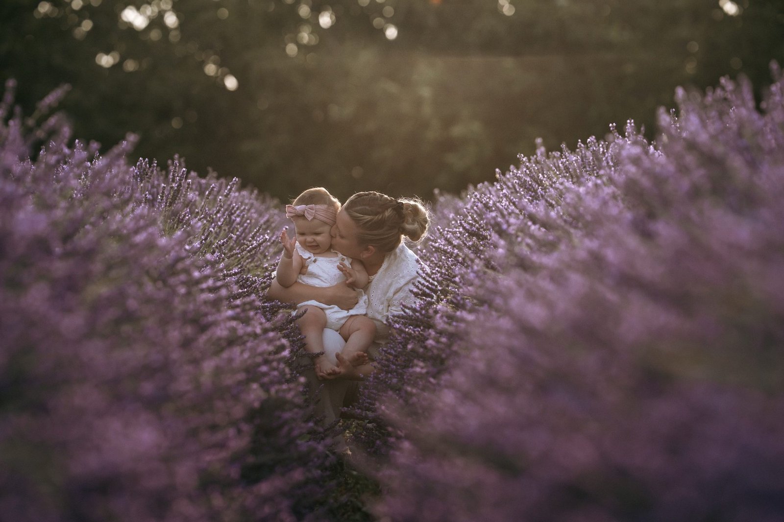 Bébé sent une fleur de lavande, entourée de ses parents