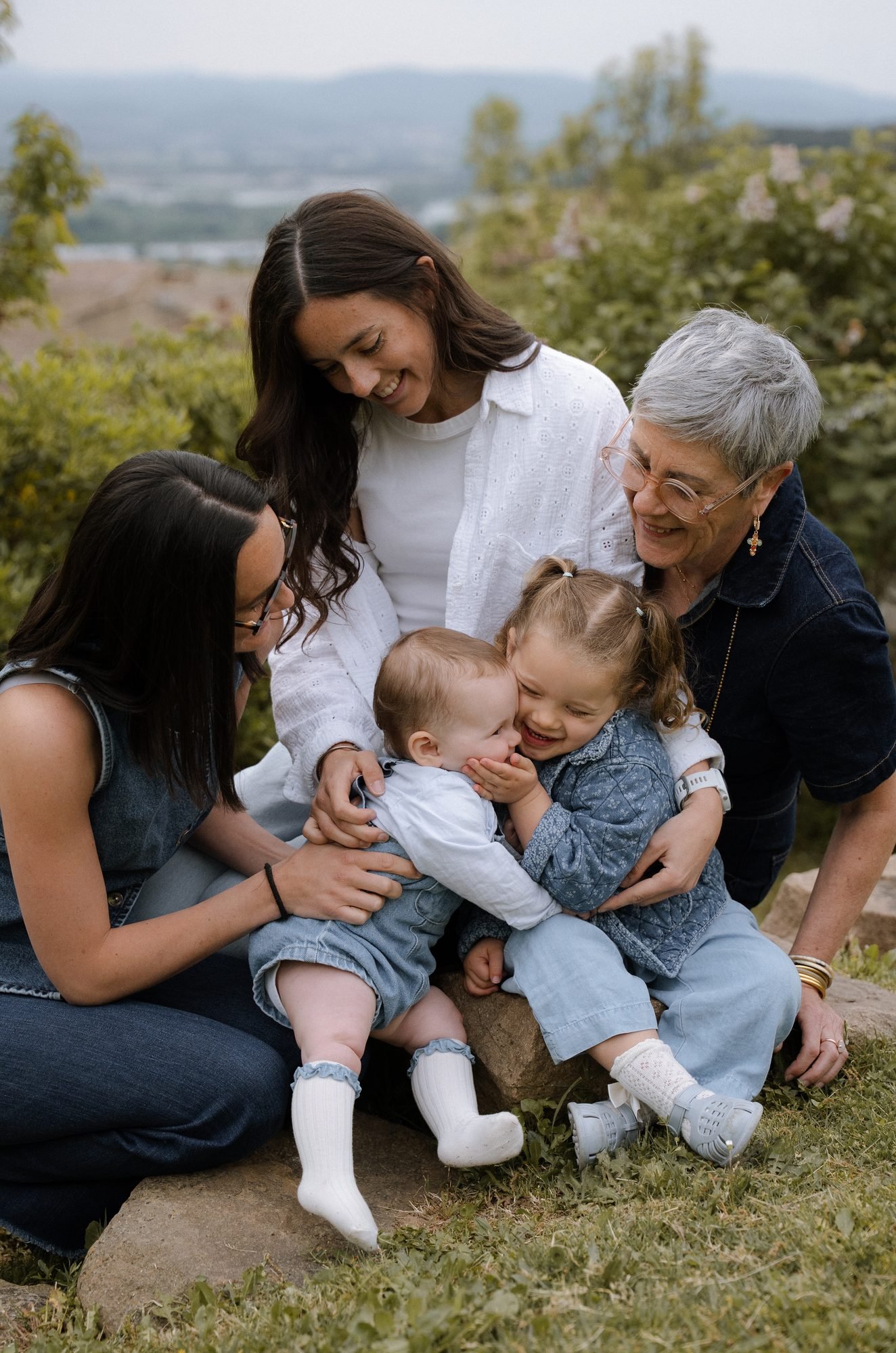 Trois générations de femmes réunies avec deux jeunes enfants, en extérieur
