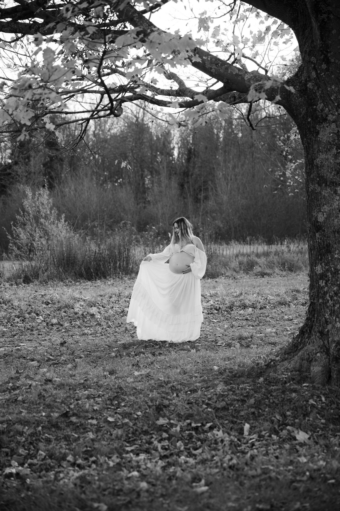 Ventre de femme enceinte tenant des tulipes roses