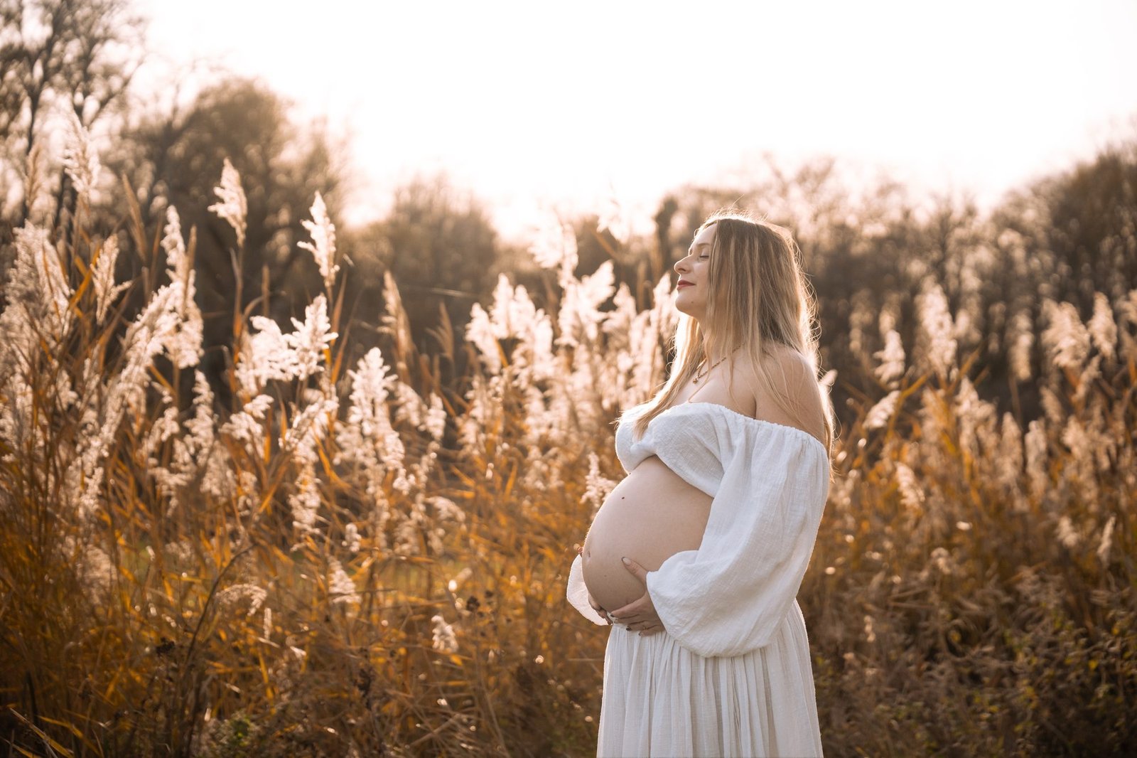 Femme enceinte en chemise fleurie, main sur le ventre