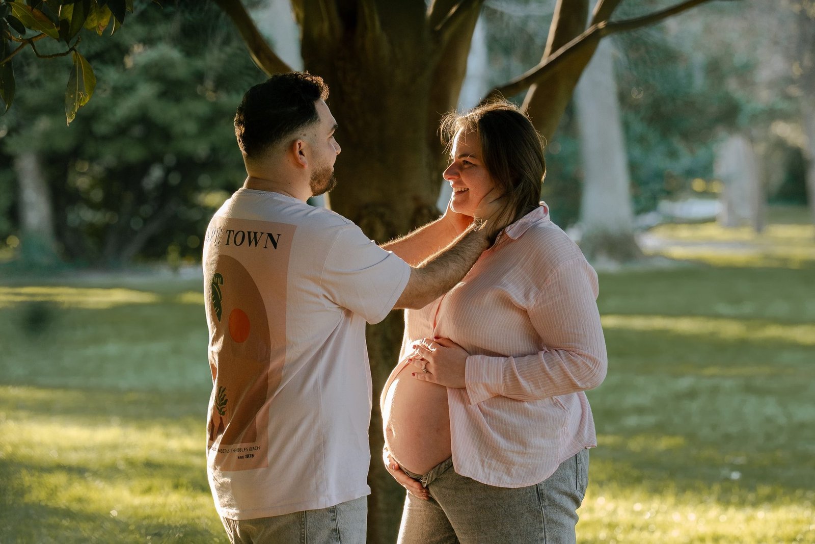 Femme enceinte assise, chemise ouverte, lumière tamisée