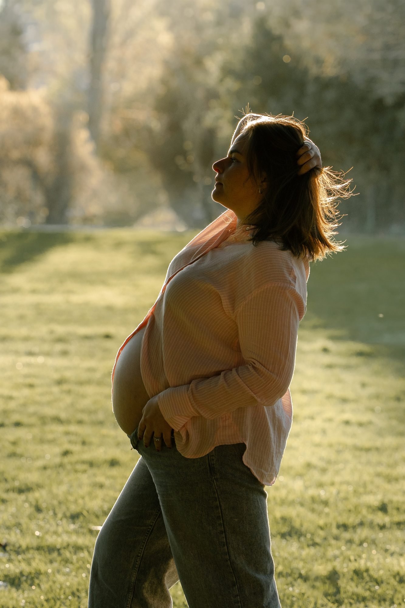 Ventre de femme enceinte orné de fleurs roses et oranges