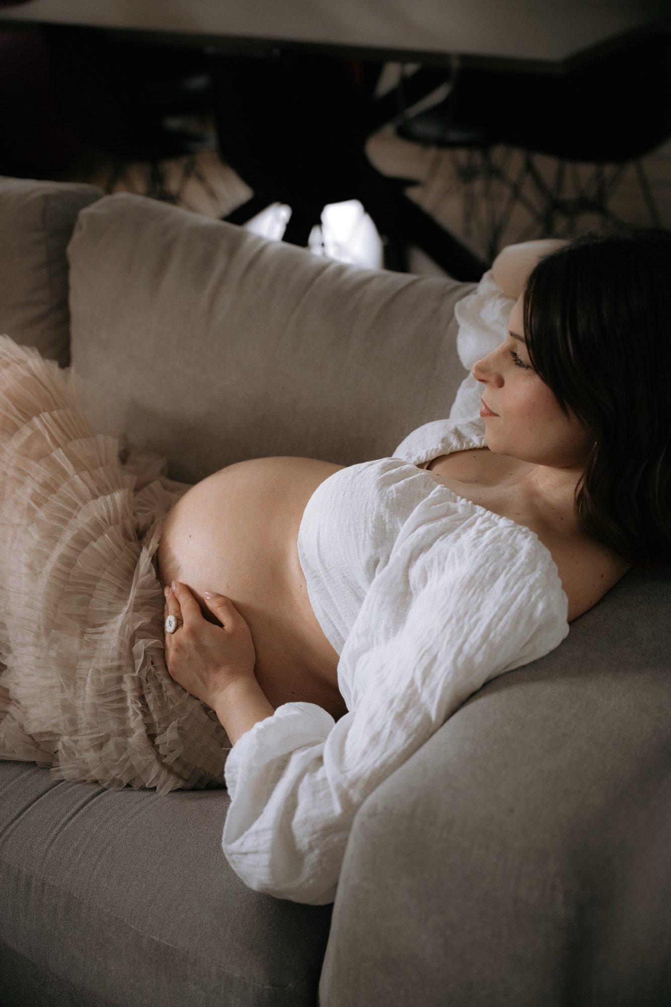 Femme enceinte de profil devant un rideau clair, noir et blanc