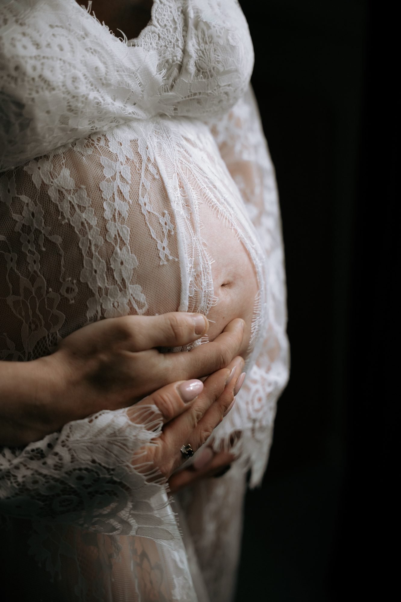 Femme enceinte en noir et blanc, allongée sur un lit