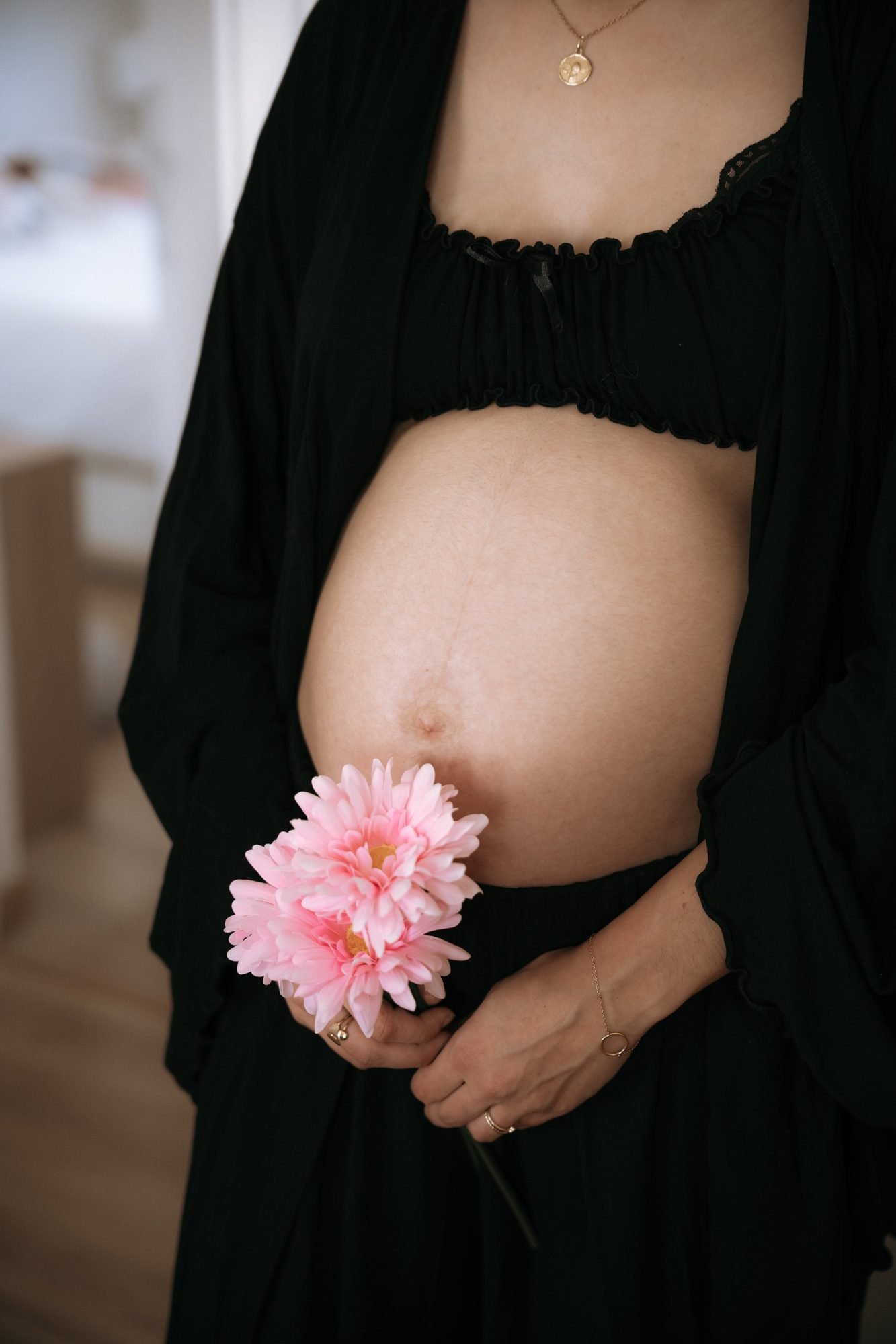 Femme enceinte tenant un bouquet de fleurs roses et blanches