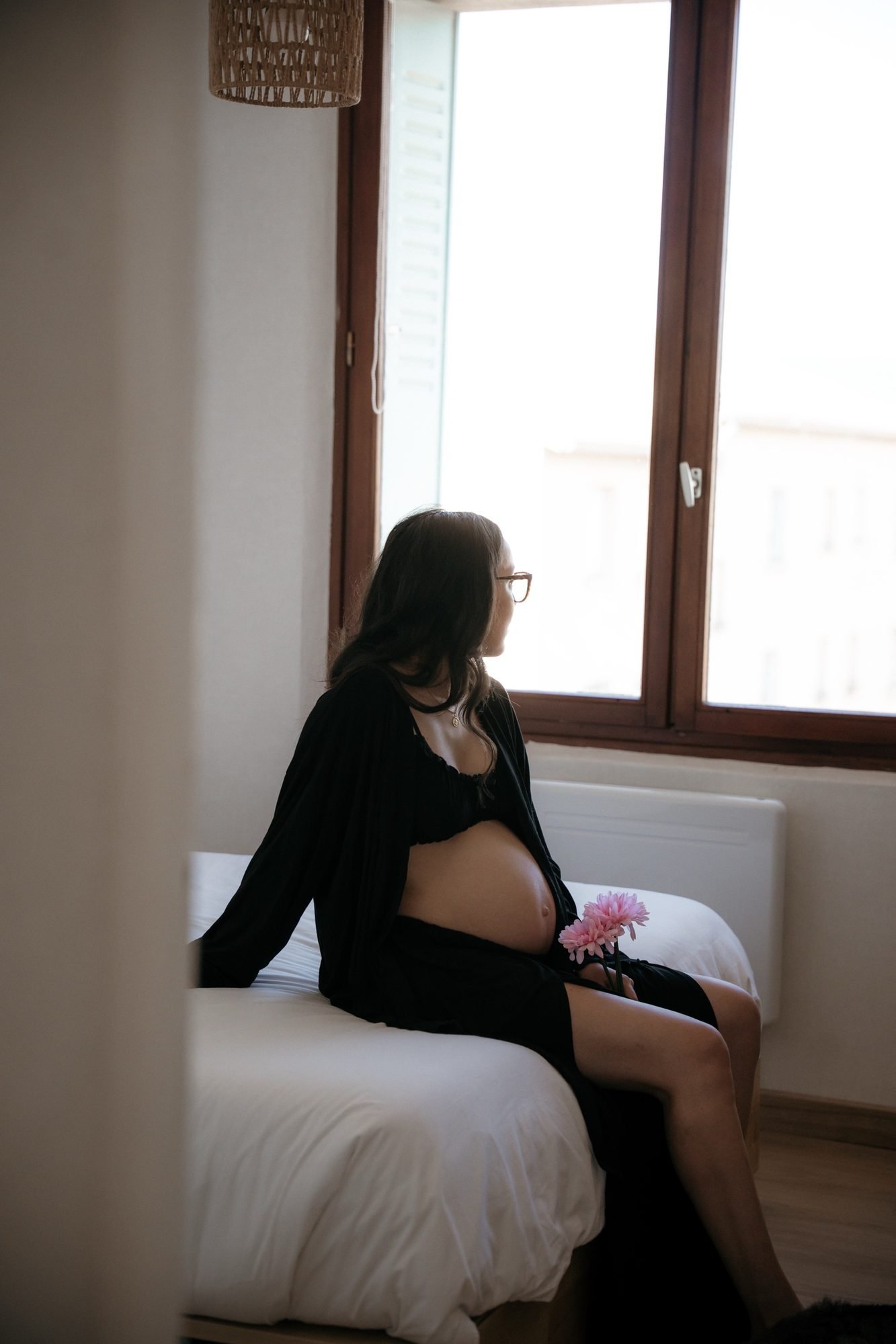Femme enceinte de profil dans une rivière, cascade en arrière-plan