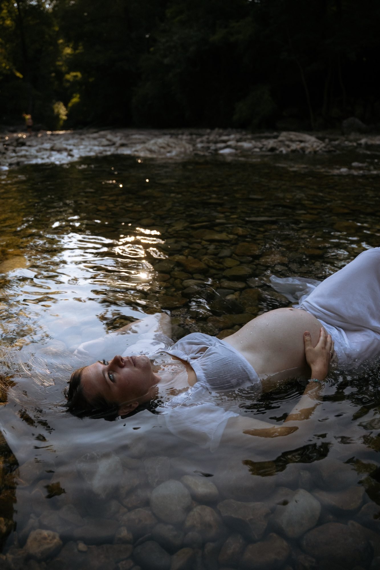 Femme enceinte en extérieur au coucher du soleil