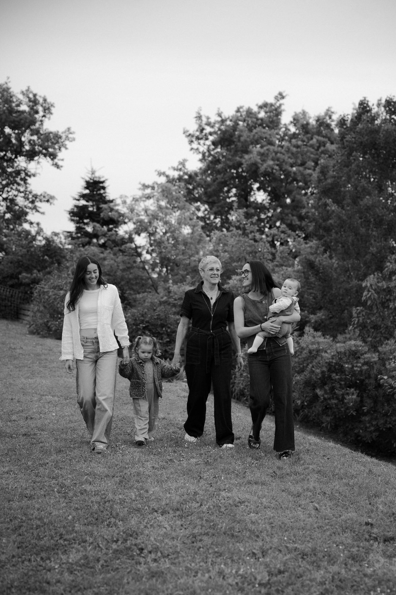 Grand-mère et petits-enfants se tenant par la main dans l'herbe