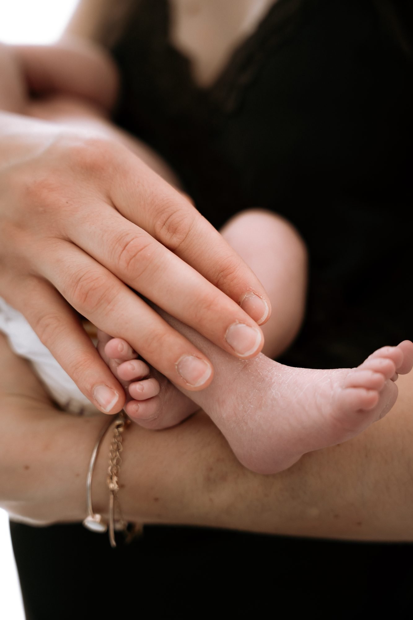 Mère allongée allaitant son bébé, lumière filtrée par un rideau