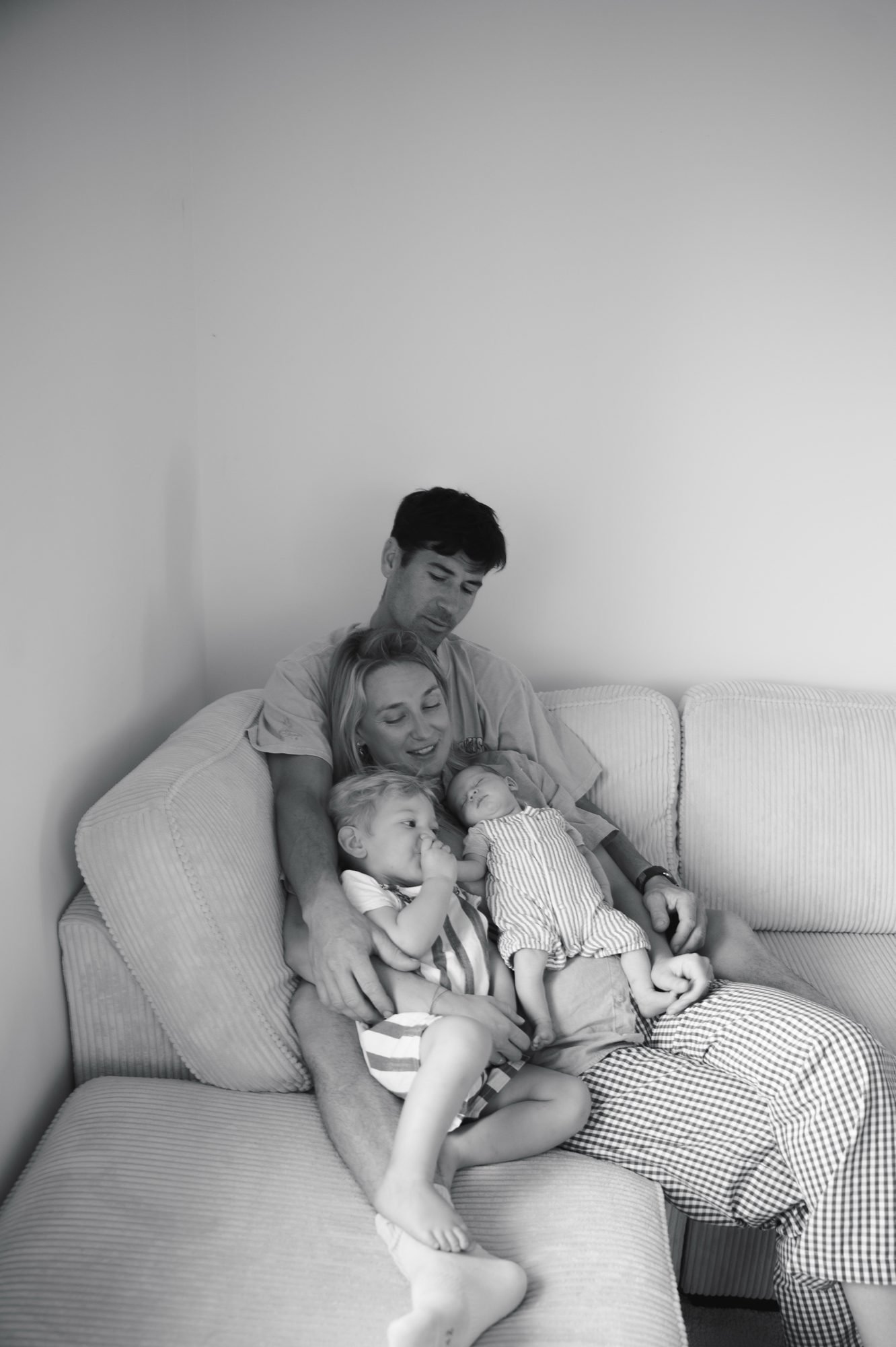 Père allongé sur un canapé avec ses deux enfants, noir et blanc