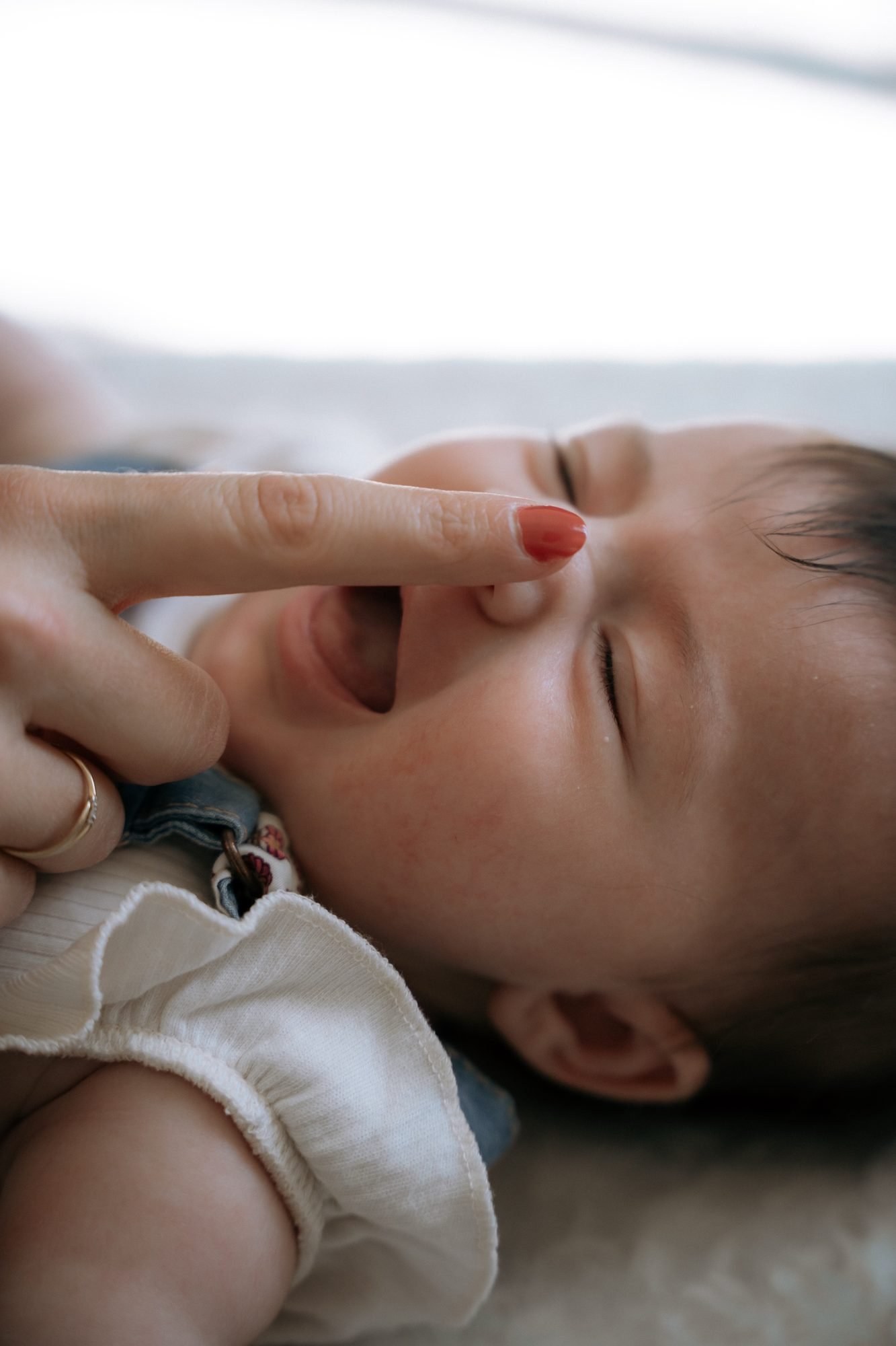 Parent chatouillant le nez de son bébé qui rit