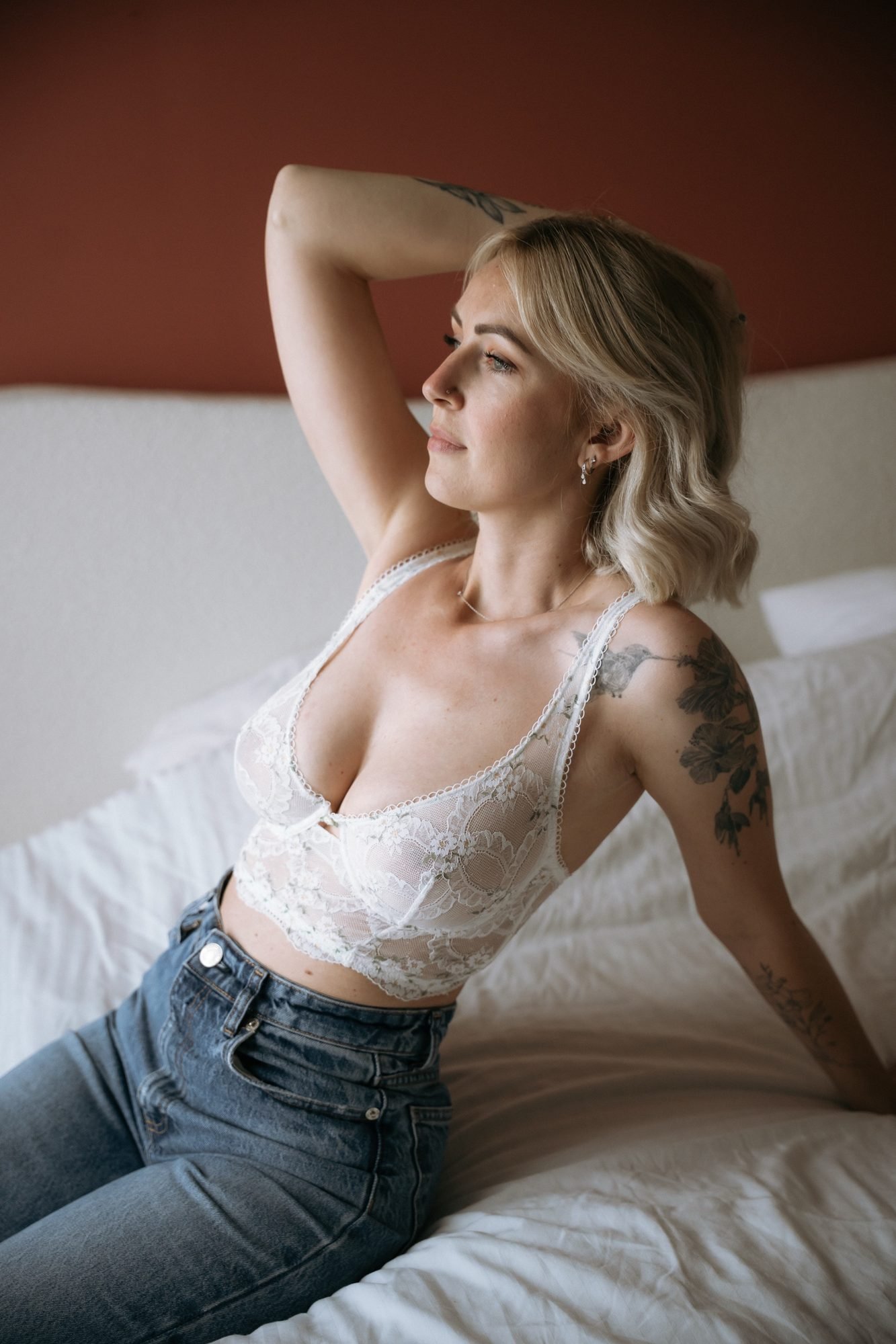 Allongée sur le lit, dentelle blanche et tatouages