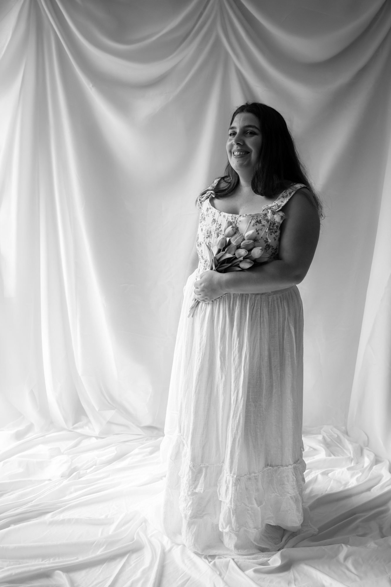 Portrait en noir et blanc, sourire léger et robe à fleurs