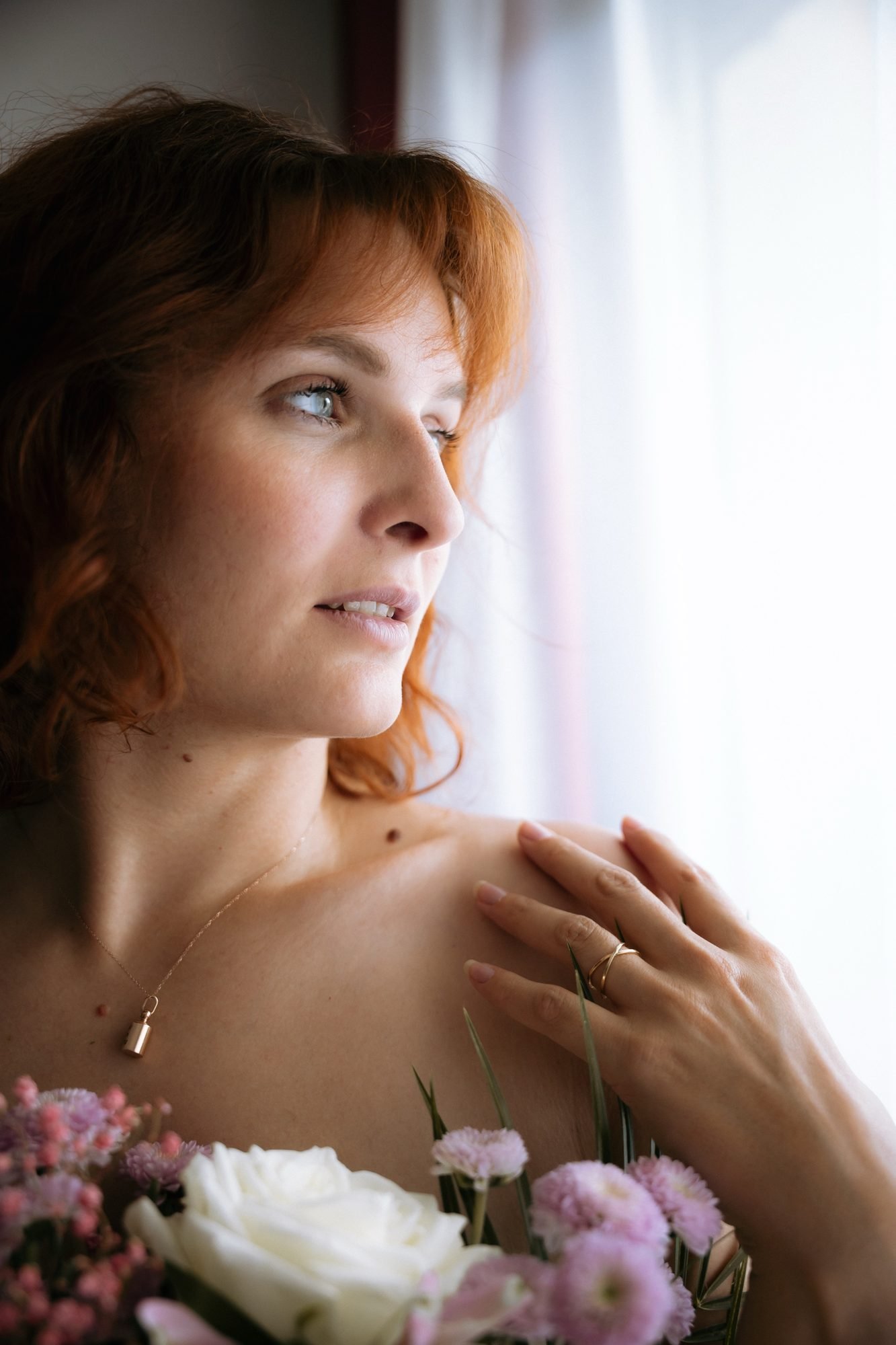 Profil apaisé, bouquet blanc et rose contre l'épaule